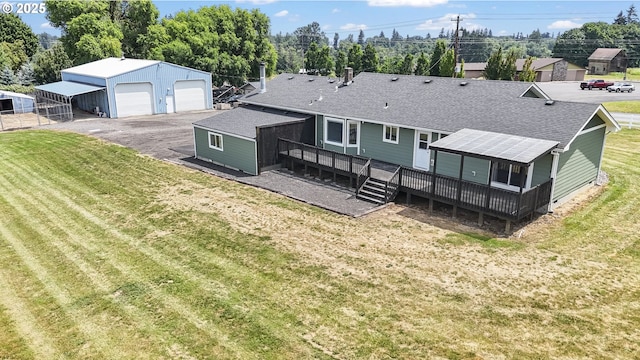 33549 Wikstrom Rd, Scappoose, OR 97056 - back of property featuring a shingled roof, an outbuilding, a detached garage, a deck, and a lawn