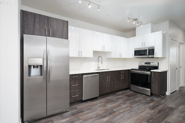 kitchen featuring appliances with stainless steel finishes, decorative backsplash, dark hardwood / wood-style floors, white cabinets, and sink