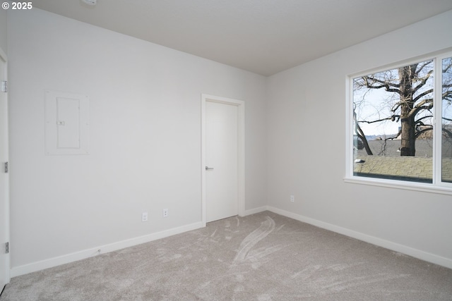 empty room with light colored carpet and electric panel