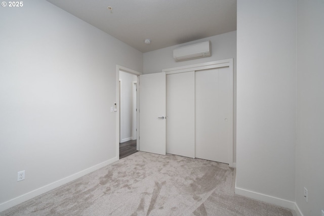 unfurnished bedroom with a closet, light carpet, and a wall mounted air conditioner