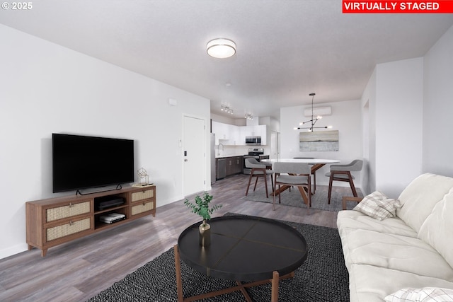 living room with light wood-type flooring and a notable chandelier