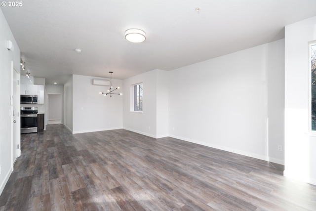 unfurnished living room with dark wood-type flooring and a notable chandelier