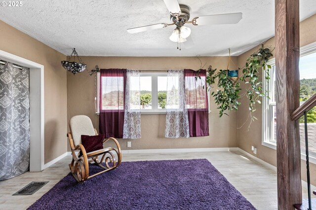 1112 S 6th St, Cottage Grove, OR 97424 - sitting room featuring wood finished floors, plenty of natural light, a ceiling fan, and a textured ceiling