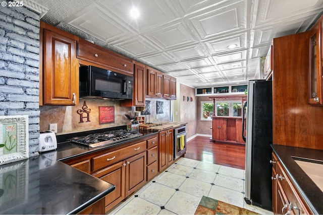 1112 S 6th St, Cottage Grove, OR 97424 - kitchen with appliances with stainless steel finishes, an ornate ceiling, dark countertops, brown cabinetry, and decorative backsplash