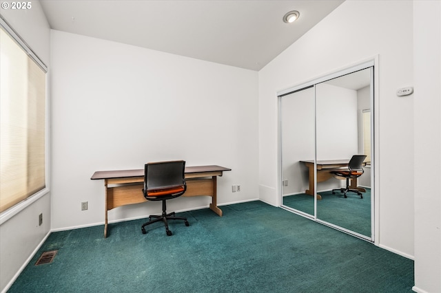 interior space with visible vents, dark colored carpet, and baseboards