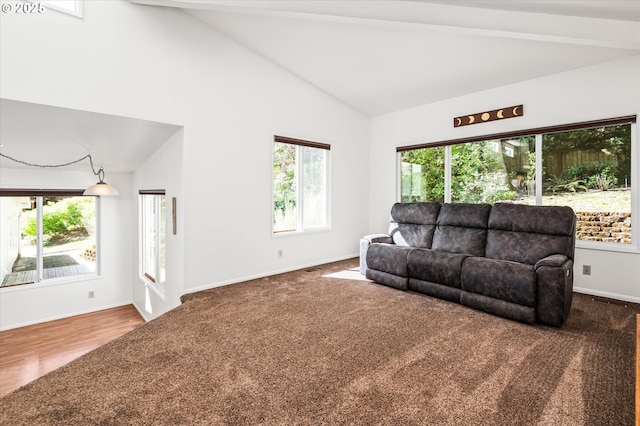 living room featuring lofted ceiling with beams, carpet floors, and a tile fireplace
