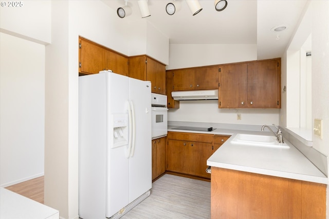 interior space with light countertops, light wood-style floors, baseboards, and white appliances