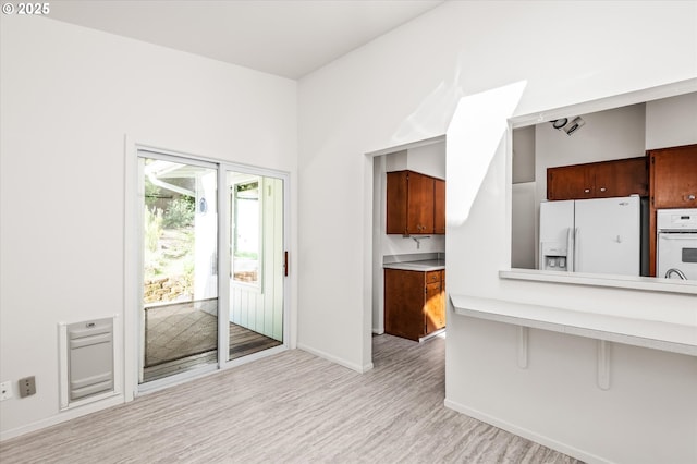 kitchen with brown cabinets, light countertops, and white appliances