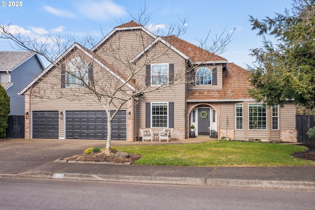 view of property with a garage and a front lawn