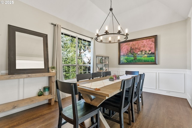 dining space with dark wood-type flooring, lofted ceiling, and a chandelier