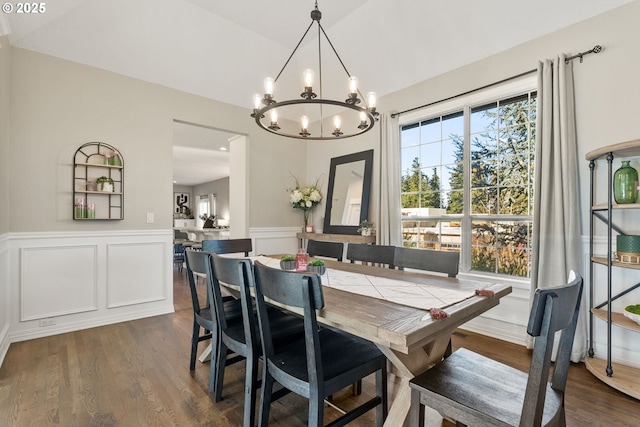 dining space featuring dark wood-type flooring and a notable chandelier