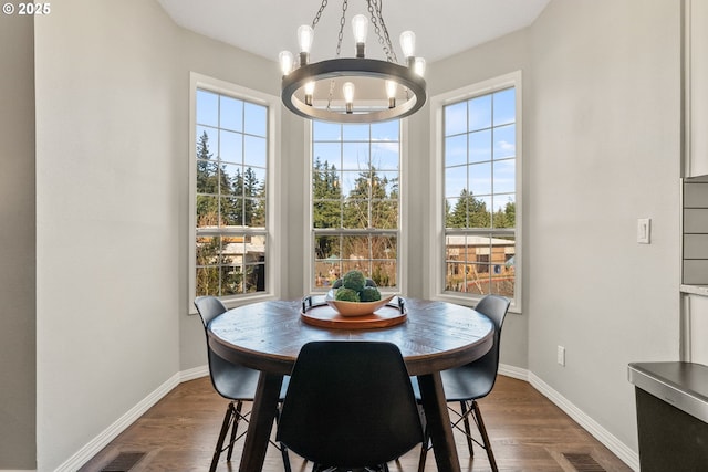 dining area with dark hardwood / wood-style flooring, plenty of natural light, and an inviting chandelier