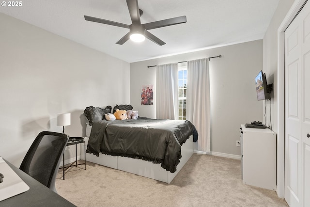 carpeted bedroom featuring ceiling fan and a closet