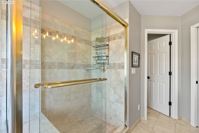 bathroom with an enclosed shower and tile patterned flooring