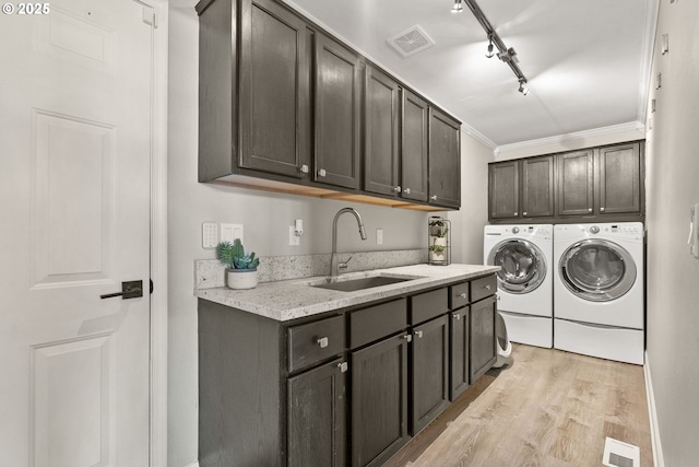 washroom with separate washer and dryer, sink, cabinets, light hardwood / wood-style floors, and crown molding