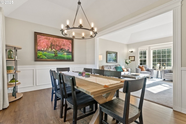 dining area featuring wood-type flooring and vaulted ceiling