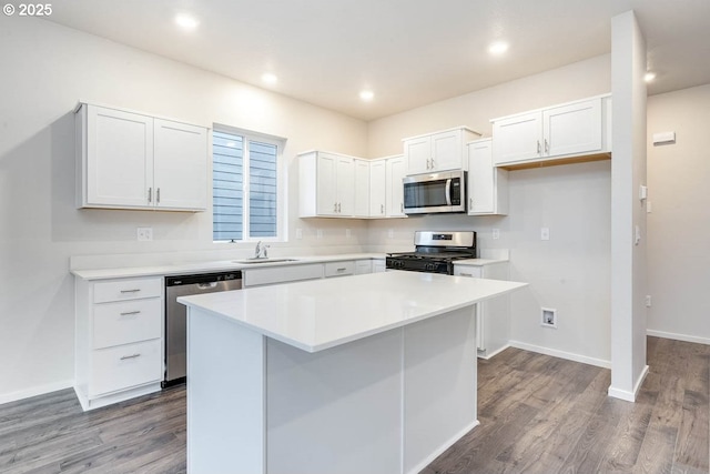 2990 T St, Springfield, OR 97477 - kitchen with stainless steel appliances, dark wood-type flooring, white cabinets, a kitchen island, and light countertops