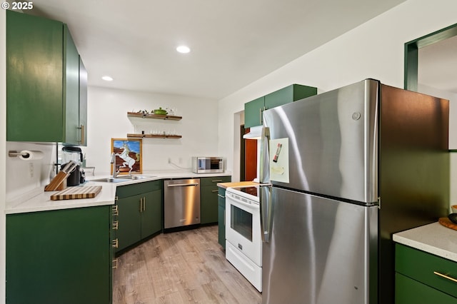14511 NE Brazee Ct, Portland, OR 97230 - kitchen with stainless steel appliances, green cabinetry, open shelves, a sink, and light wood-type flooring