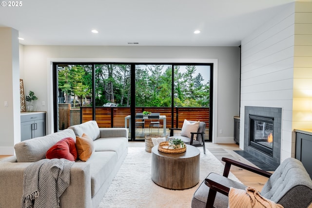 living room with light wood-type flooring and a fireplace