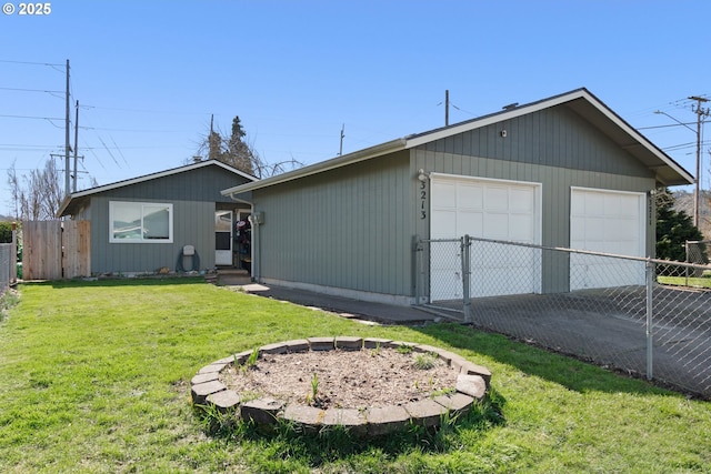 exterior space with a detached garage, a front lawn, fence, an outdoor structure, and a gate