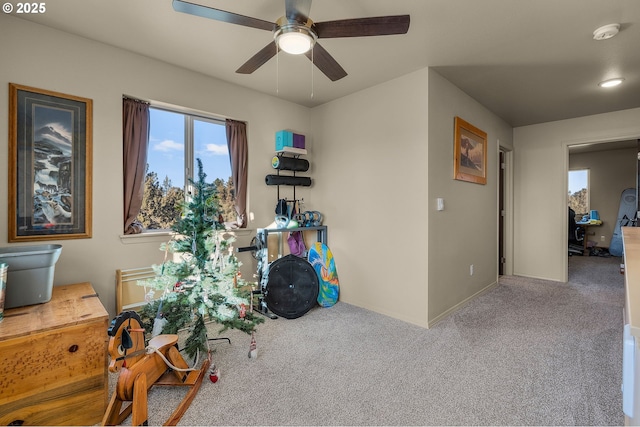 carpeted office space with ceiling fan