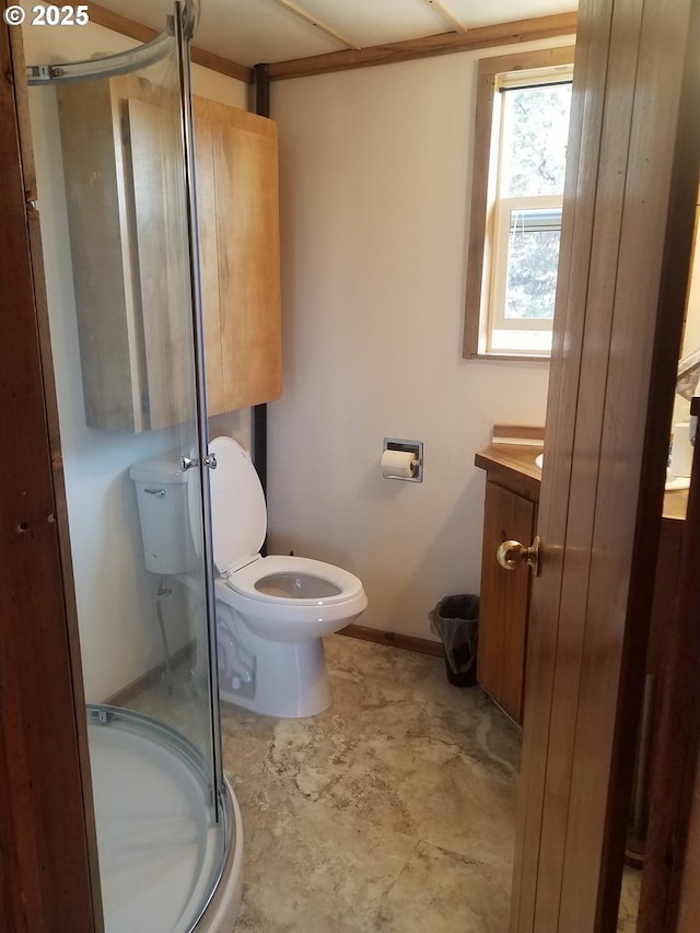 bathroom featuring vanity, a shower with shower door, and toilet