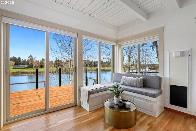 sunroom featuring wood ceiling, beam ceiling, and a water view