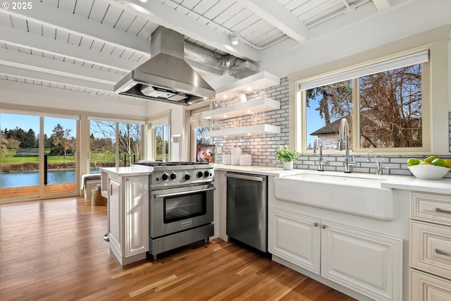 10150 S Riverside Dr, Portland, OR 97219 - kitchen with appliances with stainless steel finishes, island range hood, a peninsula, light countertops, and light wood-style flooring