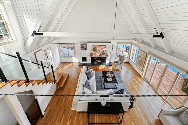 living room with high vaulted ceiling, hardwood / wood-style floors, wood ceiling, and beam ceiling