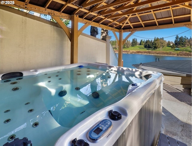 view of patio with a gazebo, a hot tub, and a water view