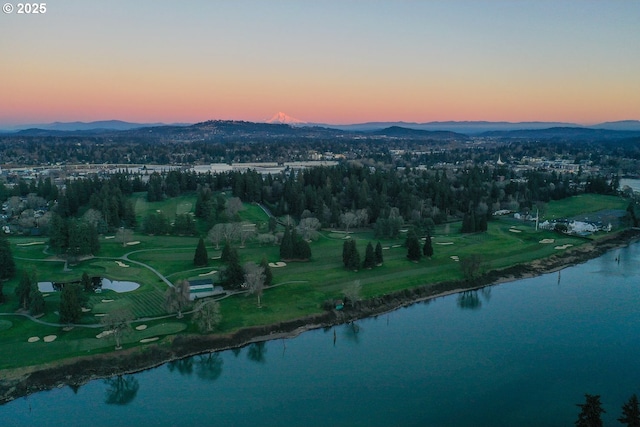 aerial view at dusk featuring a water and mountain view