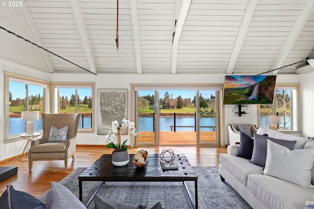 sunroom / solarium featuring lofted ceiling with beams