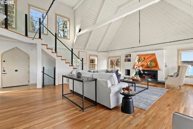 living room featuring wood ceiling, beam ceiling, high vaulted ceiling, and light wood-type flooring