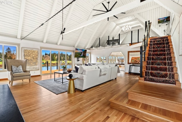 living room featuring high vaulted ceiling, beamed ceiling, hardwood / wood-style flooring, a notable chandelier, and wood ceiling