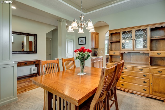 1551 S 14th Cir, Ridgefield, WA 98642 - dining space featuring light carpet, ornate columns, arched walkways, a tray ceiling, and recessed lighting