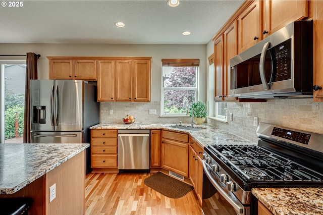 1551 S 14th Cir, Ridgefield, WA 98642 - kitchen with appliances with stainless steel finishes, light wood-style floors, recessed lighting, light stone counters, and decorative backsplash