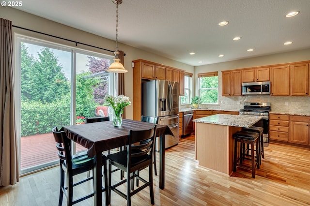 1551 S 14th Cir, Ridgefield, WA 98642 - kitchen with appliances with stainless steel finishes, recessed lighting, light wood-style floors, backsplash, and a center island