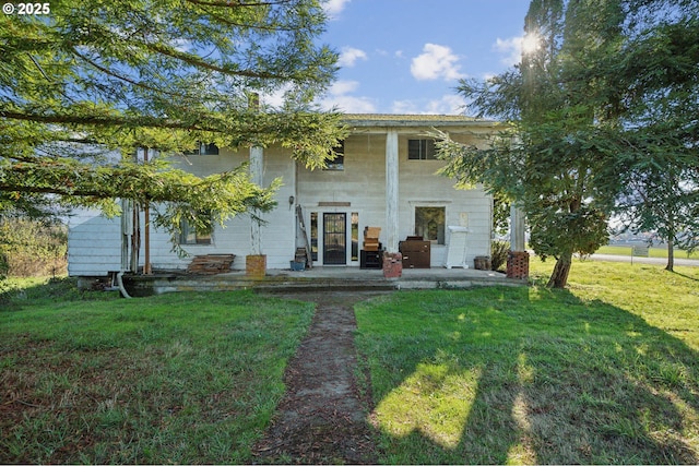 back of house with a patio area and a lawn