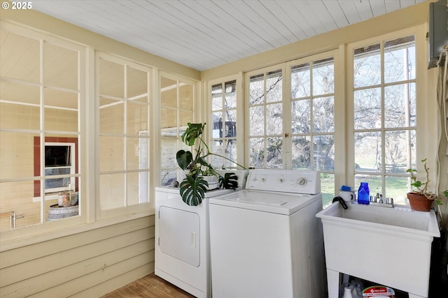 washroom featuring wooden ceiling, laundry area, a sink, light wood-style floors, and washer and clothes dryer