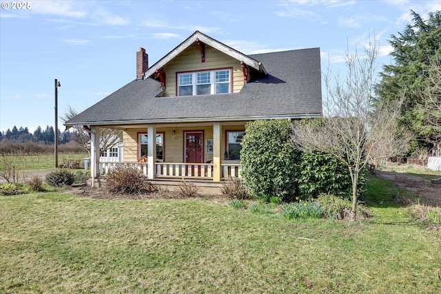 bungalow-style home with a shingled roof, a front lawn, covered porch, and a chimney