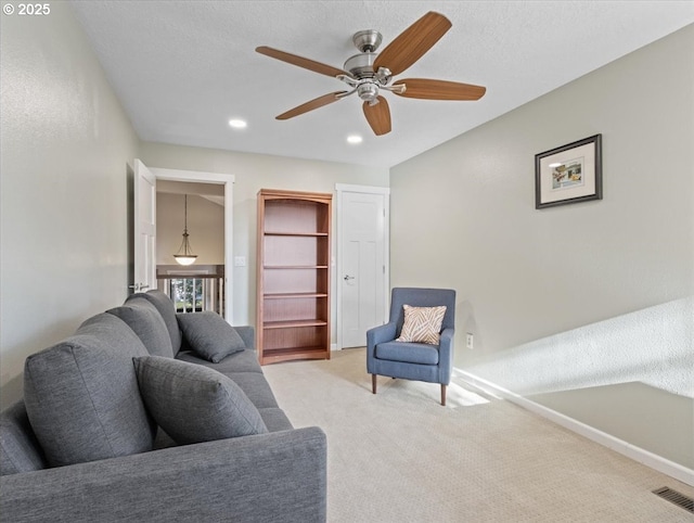 living room featuring recessed lighting, visible vents, light carpet, a textured ceiling, and baseboards