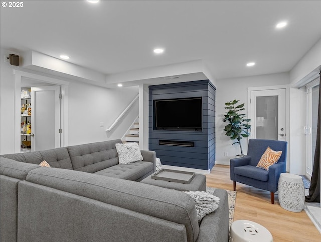 living area with stairway, wood finished floors, and recessed lighting