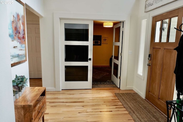 entrance foyer with light wood-style flooring and baseboards