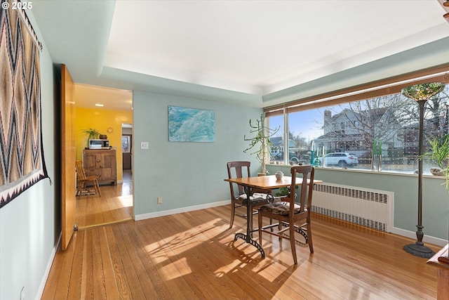 dining area with radiator and light hardwood / wood-style flooring