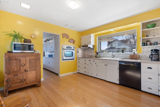 kitchen featuring sink, white cabinetry, tasteful backsplash, light hardwood / wood-style flooring, and stainless steel appliances