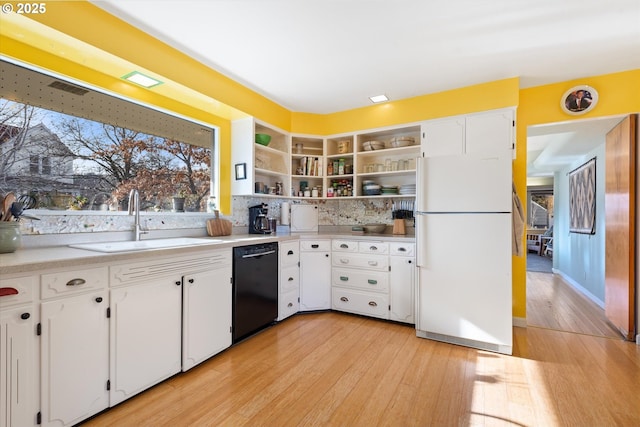 kitchen with black dishwasher, sink, white fridge, and white cabinets