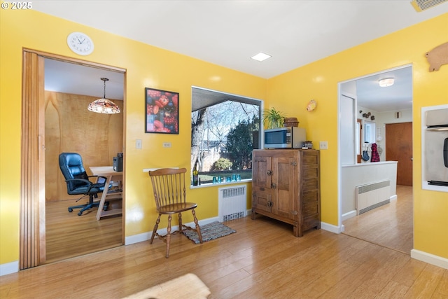 sitting room with hardwood / wood-style flooring and radiator