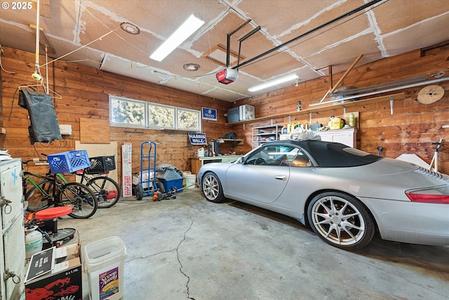 garage featuring a garage door opener and wood walls