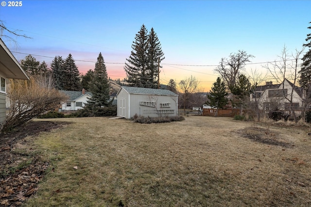 yard at dusk featuring a shed