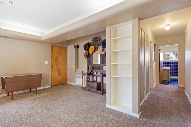 hall featuring built in shelves, radiator heating unit, and carpet flooring